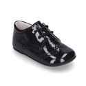 Laces up style shoes for babies in patent leather.