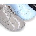 Laces up style shoes for babies in patent leather.