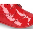 Laces up style shoes for babies in patent leather.