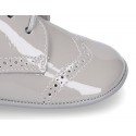 Laces up style shoes for babies in patent leather.