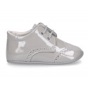 Laces up style shoes for babies in patent leather.