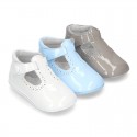 New T-Strap shoes for babies with Velcro strap, button and waves design in patent leather.