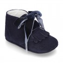 Suede leather little bootie for babies with velvet ties closure and fringed design.