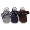 Suede leather little bootie for babies with velvet ties closure and fringed design.