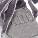 Suede leather little bootie for babies with velvet ties closure and fringed design.