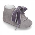 Suede leather little bootie for babies with velvet ties closure and fringed design.