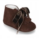 Suede leather little bootie for babies with velvet ties closure and fringed design.