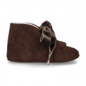 Suede leather little bootie for babies with velvet ties closure and fringed design.