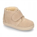 New suede leather little bootie sneaker style with fake hair lining and velcro strap.