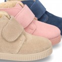 New suede leather little bootie sneaker style with fake hair lining and velcro strap.