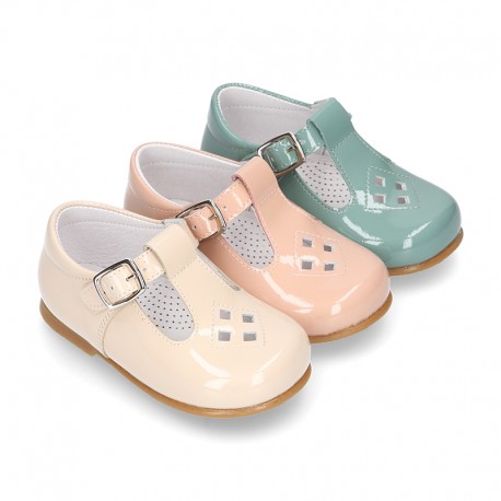 Little T-Strap shoes with perforated design in patent leather in pastel colors.