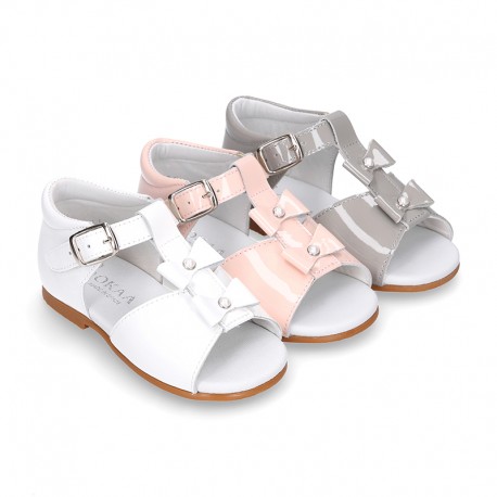 Patent leather Little T-Strap Sandal shoes with buckle fastening and with bows and pearls design.