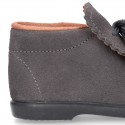 Booties with shoelaces closure with POMPONS in suede leather for kids.