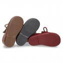 Booties with shoelaces closure with POMPONS in suede leather for kids.