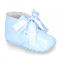 Patent leather little bootie for babies with silk ties closure design.