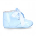 Patent leather little bootie for babies with silk ties closure design.