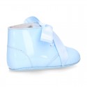 Patent leather little bootie for babies with silk ties closure design.