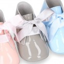 Patent leather little bootie for babies with silk ties closure design.