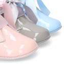 Patent leather little bootie for babies with silk ties closure design.