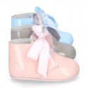 Patent leather little bootie for babies with silk ties closure design.