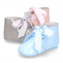 Patent leather little bootie for babies with silk ties closure design.