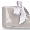 Patent leather little bootie for babies with silk ties closure design.