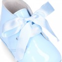 Patent leather little bootie for babies with silk ties closure design.