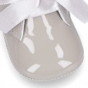 Patent leather little bootie for babies with silk ties closure design.