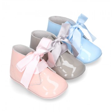 Patent leather little bootie for babies with silk ties closure design.