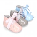 Patent leather little bootie for babies with silk ties closure design.