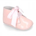 Patent leather little bootie for babies with silk ties closure design.