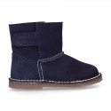 Suede leather Boots with velcro strap closure and fake hair lining.