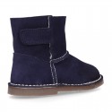 Suede leather Boots with velcro strap closure and fake hair lining.