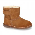 Suede leather Boots with velcro strap closure and fake hair lining.