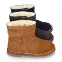 Suede leather Boots with velcro strap closure and fake hair lining.