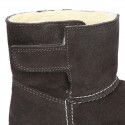 Suede leather Boots with velcro strap closure and fake hair lining.