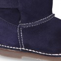 Suede leather Boots with velcro strap closure and fake hair lining.