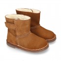 Suede leather Boots with velcro strap closure and fake hair lining.