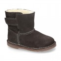 Suede leather Boots with velcro strap closure and fake hair lining.