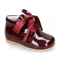 Classic patent leather ankle boots to dress with SILK ties closure for first steps.