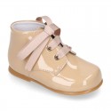 Classic pastel color patent leather ankle boots to dress with ties closure for first steps.