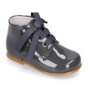 Classic pastel color patent leather ankle boots to dress with ties closure for first steps.