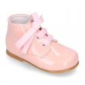 Classic pastel color patent leather ankle boots to dress with ties closure for first steps.