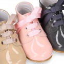 Classic pastel color patent leather ankle boots to dress with ties closure for first steps.