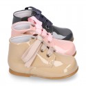 Classic pastel color patent leather ankle boots to dress with ties closure for first steps.