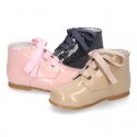 Classic pastel color patent leather ankle boots to dress with ties closure for first steps.