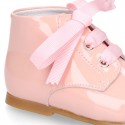 Classic pastel color patent leather ankle boots to dress with ties closure for first steps.
