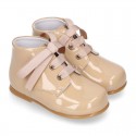 Classic pastel color patent leather ankle boots to dress with ties closure for first steps.