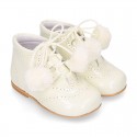 Classic patent leather English style bootie for first steps with POMPONS.