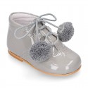 Classic patent leather English style bootie for first steps with POMPONS.